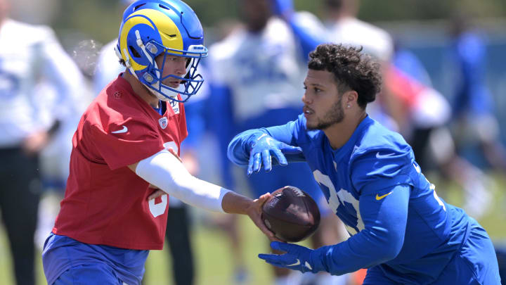 May 28, 2024; Thousand Oaks, CA, USA;  Los Angeles Rams quarterback Matthew Stafford (9) hands off to running back Blake Corum (22) during OTAs at California Lutheran University. Mandatory Credit: Jayne Kamin-Oncea-USA TODAY Sports