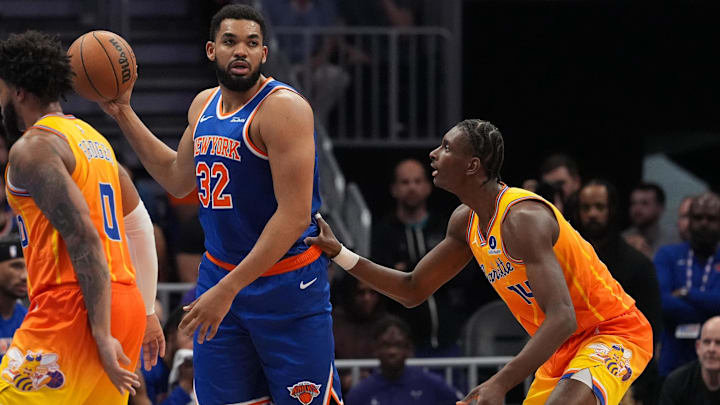Mar 26, 2026; Charlotte, North Carolina, USA; New York Knicks center/forward Karl-Anthony Towns (32) looks to pass defended by Charlotte Hornets forward Moussa Diabaté (14) during the second quarter at the Spectrum Center. Mandatory Credit: Jim Dedmon-Imagn Images