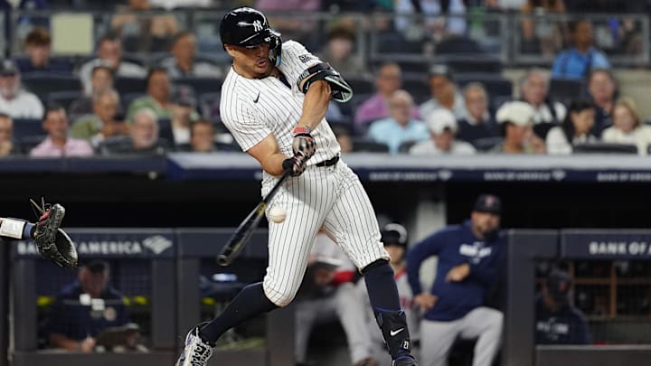 Sep 12, 2024; Bronx, New York, USA;  New York Yankees designated hitter Giancarlo Stanton (27) hits a single against the Boston Red Sox during the fourth inning at Yankee Stadium.