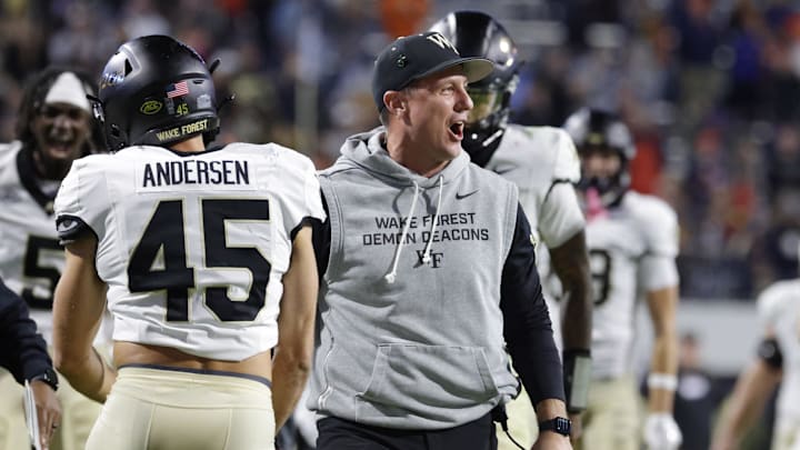 Nov 8, 2025; Charlottesville, Virginia, USA; Wake Forest Demon Deacons head coach Jake Dickert (center) celebrates with players after blocking a touchdown pass in the final seconds of the second half against the Virginia Cavaliers at Scott Stadium. Mandatory Credit: Amber Searls-Imagn Images