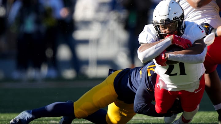 Cincinnati Bearcats running back Corey Kiner (21) carries the ball in the first quarter during an NCAA college football game between the Cincinnati Bearcats and the West Virginia Mountaineers, Saturday, Nov. 18, 2023, at Milan Puskar Stadium in Morgantown, W. Va. Cincinnati Bearcats running back Corey Kiner (21) carries the ball in the first quarter during an NCAA college football game between the Cincinnati Bearcats and the West Virginia Mountaineers, Saturday, Nov. 18, 2023, at Milan Puskar Stadium in Morgantown, W. Va.