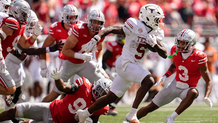 Texas Longhorns running back Quintrevion Wisner (5) runs past Ohio State Buckeyes defensive end Eddrick Houston (96) during the second half of the NCAA football game at Ohio Stadium on Aug. 30, 2025. Ohio State won 14-7.