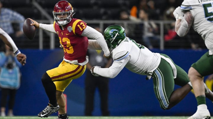 Jan 2, 2023; Arlington, Texas, USA; USC Trojans quarterback Caleb Williams (13) and Tulane Green Wave defensive lineman Patrick Jenkins (0) in action during the game between the USC Trojans and the Tulane Green Wave in the 2023 Cotton Bowl at AT&T Stadium. 