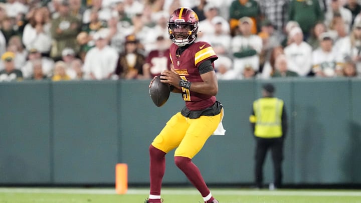 Sep 11, 2025; Green Bay, Wisconsin, USA; Washington Commanders quarterback Jayden Daniels (5) looks to pass against the Green Bay Packers in the second quarter at Lambeau Field. 