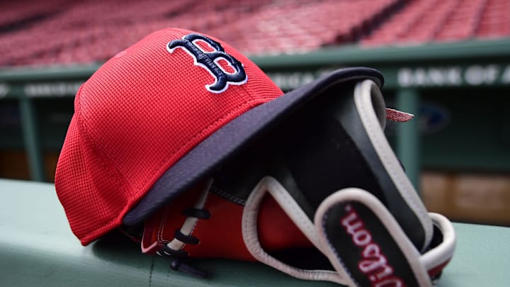 May 18, 2025; Boston, Massachusetts, USA;  A Boston Red Sox hat and glove rests on the railing by the dugout prior to a game against the Atlanta Braves at Fenway Park. Mandatory Credit: Bob DeChiara-Imagn Images