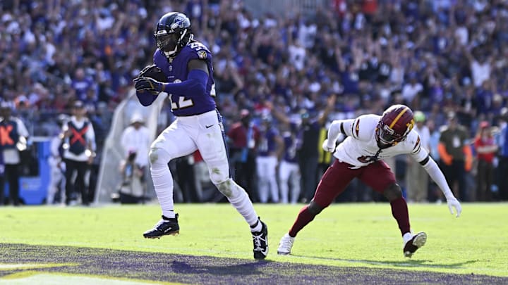 Baltimore Ravens running back Derrick Henry (22) rushes by Washington Commanders cornerback Mike Sainristil (0) for a second-half touchdown at M&T Bank Stadium. 