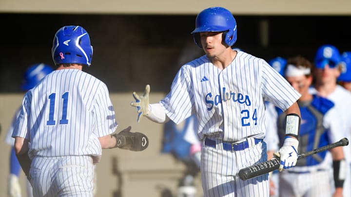 Sartell baseball sophomore Mateo Segura (24) high fives Cayden Behrmann (11) after the senior scored during a game against the St. Cloud Crush on May 8, 2025 at St. Cloud Orthopedic Field. The Sabres won 5-0.