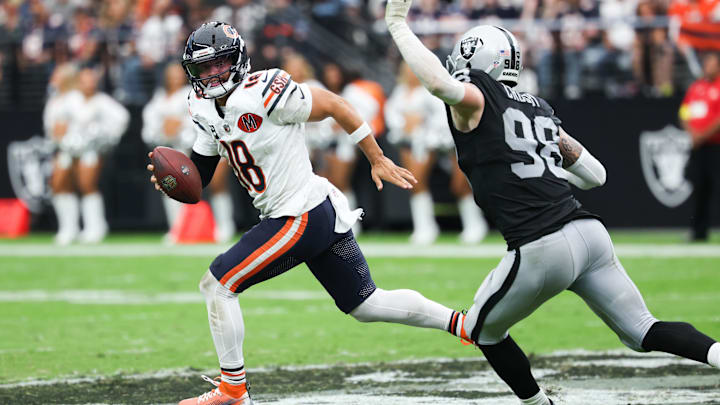 Sep 28, 2025; Paradise, Nevada, USA; Chicago Bears quarterback Caleb Williams (18) looks for an open receiver while being pressured by Las Vegas Raiders defensive end Maxx Crosby (98) in the second quarter at Allegiant Stadium. Mandatory Credit: Kiyoshi Mio-Imagn Images