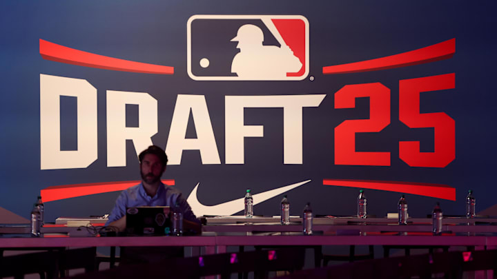 Jul 13, 2025; Atlanta, GA, USA; A reporter sits in front of signage before the MLB Draft at The Coca-Cola Roxy. Mandatory Credit: Brett Davis-Imagn Images
