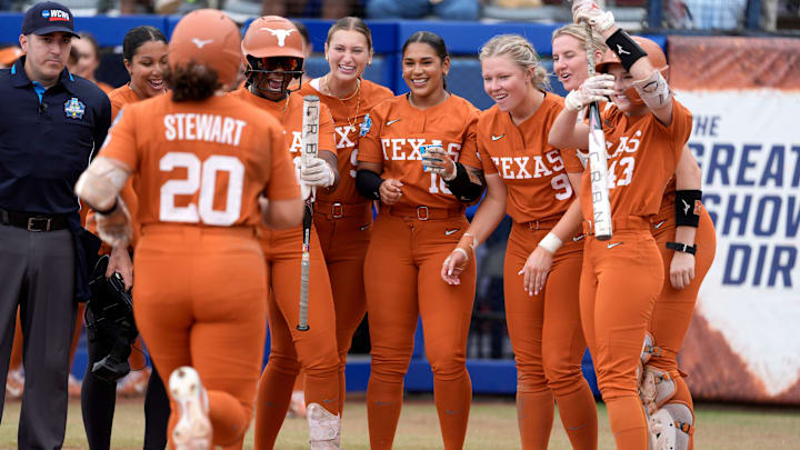 Texas players greet Katie Stewart (20) at home plate after she hit a home run in the in the sixth inning of a Women's College World Series softball game between the Texas Longhorns and the Florida Gators at Devon Park in Oklahoma City, Thursday, May 29, 2025.