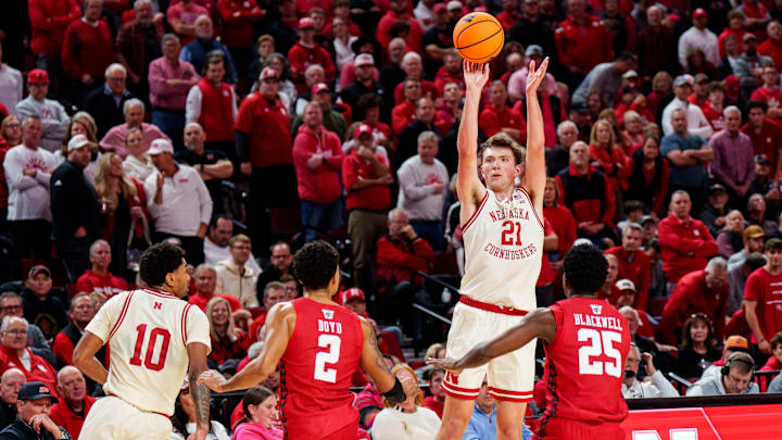 Dec 10, 2025; Lincoln, Nebraska, USA; Nebraska Cornhuskers forward Pryce Sandfort (21) shoots a three point basket against Wisconsin Badgers guard Nick Boyd (2) and guard John Blackwell (25) during the first half at Pinnacle Bank Arena. Mandatory Credit: Dylan Widger-Imagn Images Dec 10, 2025; Lincoln, Nebraska, USA; Nebraska Cornhuskers forward Pryce Sandfort (21) shoots a three point basket against Wisconsin Badgers guard Nick Boyd (2) and guard John Blackwell (25) during the first half at Pinnacle Bank Arena. Mandatory Credit: Dylan Widger-Imagn Images