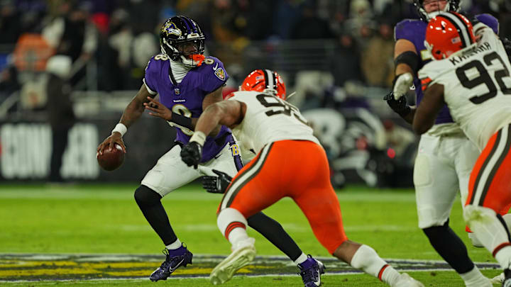 Jan 4, 2025; Baltimore, Maryland, USA; Baltimore Ravens quarterback Lamar Jackson (8) runs the ball during the second quarter against Cleveland Browns defensive end Myles Garrett (95) at M&T Bank Stadium. Mandatory Credit: Mitch Stringer-Imagn Images