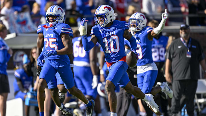 Nov 22, 2025; Dallas, Texas, USA;  SMU Mustangs safety Tyren Polley (10) and cornerback Javion Holiday (25) and cornerback Marcellus Barnes Jr. (8) celebrates after intercepting a pass during the game between the Mustangs and the Cardinals at Gerald J. Ford Stadium. Mandatory Credit: Jerome Miron-Imagn Images