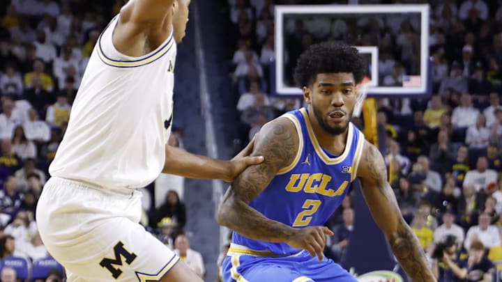 Feb 14, 2026; Ann Arbor, Michigan, USA; UCLA Bruins guard Donovan Dent (2) dribbles defended by Michigan Wolverines guard Trey McKenney (1) in the second half at Crisler Center. Mandatory Credit: Rick Osentoski-Imagn Images