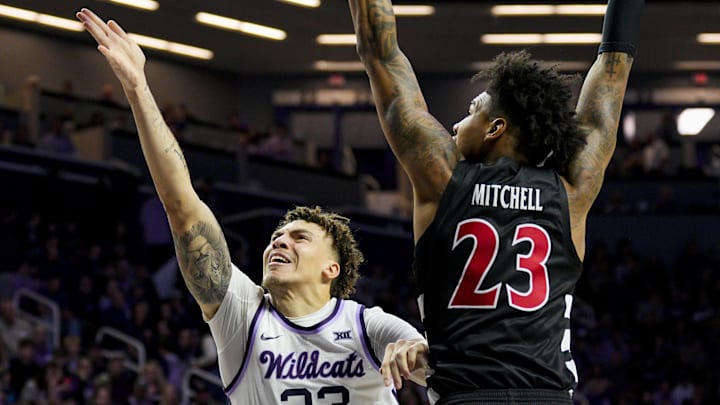 Dec 30, 2024; Manhattan, Kansas, USA; Kansas State Wildcats guard Coleman Hawkins (33) shoots against Cincinnati Bearcats forward Dillon Mitchell (23) during the second half at Bramlage Coliseum. Mandatory Credit: Jay Biggerstaff-Imagn Images