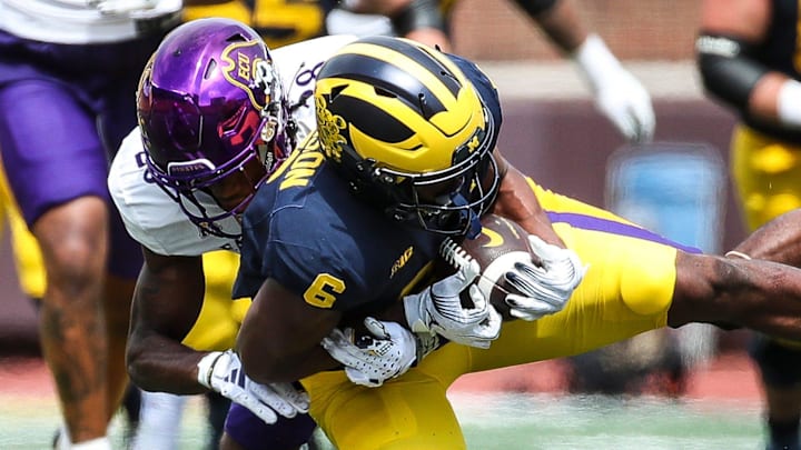 East Carolina defensive back Shavon Revel tackles Michigan wide receiver Cornelius Johnson.