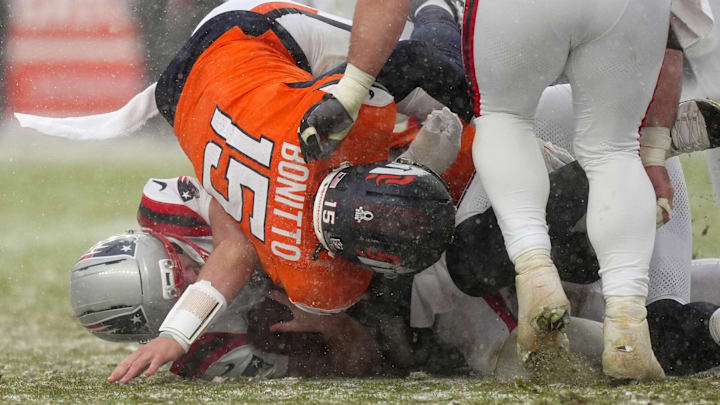 Jan 25, 2026; Denver, CO, USA; Denver Broncos linebacker Nik Bonitto (15) tackles New England Patriots quarterback Drake Maye (10) during the second half in the 2026 AFC Championship Game at Empower Field at Mile High. 