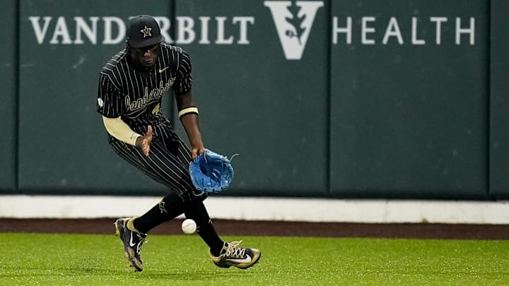 Vanderbilt center fielder RJ Austin (42) scoops up a single hit by Arkansas outfielder Justin Thomas Jr. (4) during the third inning at Hawkins Field in Nashville, Tenn., Friday, March 28, 2025.