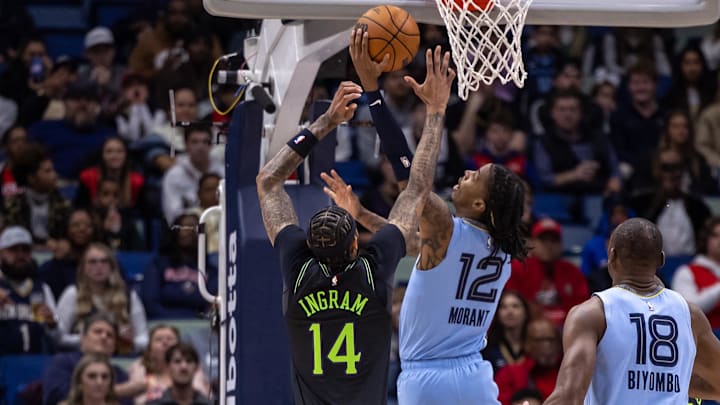 Dec 26, 2023; New Orleans, Louisiana, USA; Memphis Grizzlies guard Ja Morant (12) drives to the basket against New Orleans Pelicans forward Brandon Ingram (14) during the first half at Smoothie King Center. Mandatory Credit: Stephen Lew-Imagn Images