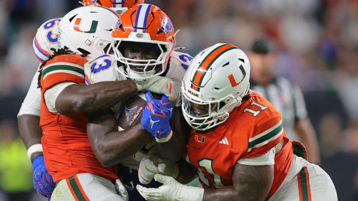 Sep 20, 2025; Miami Gardens, Florida, USA; Florida Gators running back Jadan Baugh (13) carries the football against Miami Hurricanes defensive lineman David Blay Jr. (11) during the third quarter at Hard Rock Stadium. Mandatory Credit: Sam Navarro-Imagn Images Sep 20, 2025; Miami Gardens, Florida, USA; Florida Gators running back Jadan Baugh (13) carries the football against Miami Hurricanes defensive lineman David Blay Jr. (11) during the third quarter at Hard Rock Stadium. Mandatory Credit: Sam Navarro-Imagn Images