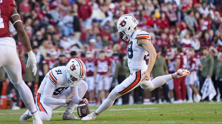 oNov 11, 2023; Fayetteville, Arkansas, USA;  Auburn Tigers place kicker Alex McPherson (38) kicks an extra point from holder Oscar Chapman (91) during the first quarter against the Arkansas Razorbacks at Donald W. Reynolds Razorback Stadium. Auburn won 48-10. Mandatory Credit: Brett Rojo-Imagn Images