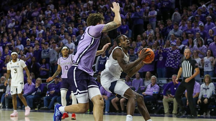 Jan 25, 2025; Manhattan, Kansas, USA; West Virginia Mountaineers guard Toby Okani (5) drives against Kansas State Wildcats forward Coleman Hawkins (33) in the second half at Bramlage Coliseum. Mandatory Credit: Scott Sewell-Imagn Images
