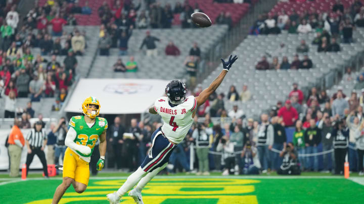 Jan 1, 2024; Glendale, AZ, USA; Liberty Flames wide receiver CJ Daniels (4) attempts to catch a pass as Oregon Ducks defensive back Evan Williams (33) defends him in the first quarter of the 2024 Fiesta Bowl at State Farm Stadium. Mandatory Credit: Joe Camporeale-USA TODAY Sports Jan 1, 2024; Glendale, AZ, USA; Liberty Flames wide receiver CJ Daniels (4) attempts to catch a pass as Oregon Ducks defensive back Evan Williams (33) defends him in the first quarter of the 2024 Fiesta Bowl at State Farm Stadium. Mandatory Credit: Joe Camporeale-USA TODAY Sports
