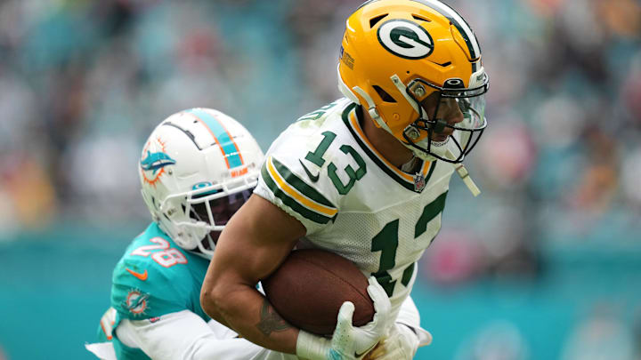 Dec 25, 2022; Miami Gardens, Florida, USA; Miami Dolphins cornerback Kader Kohou (28) tackles Green Bay Packers wide receiver Allen Lazard (13) during the second half at Hard Rock Stadium.