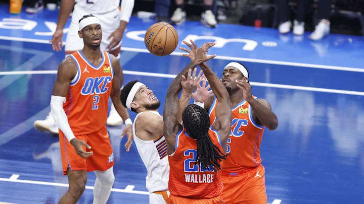 Nov 15, 2024; Oklahoma City, Oklahoma, USA; Phoenix Suns guard Devin Booker (1) fights for a rebound against Oklahoma City Thunder guard Cason Wallace (22) and guard Luguentz Dort (5) during the first quarter at Paycom Center. Mandatory Credit: Alonzo Adams-Imagn Images