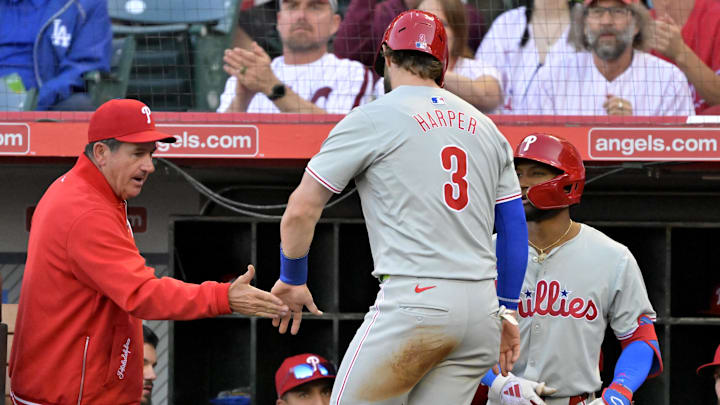 Apr 29, 2024; Anaheim, California, USA; Philadelphia Phillies first base Bryce Harper (3) is greeted at the dugout by manager Rob Thomson (59) after scoring a run in the first inning against the Los Angeles Angels at Angel Stadium.