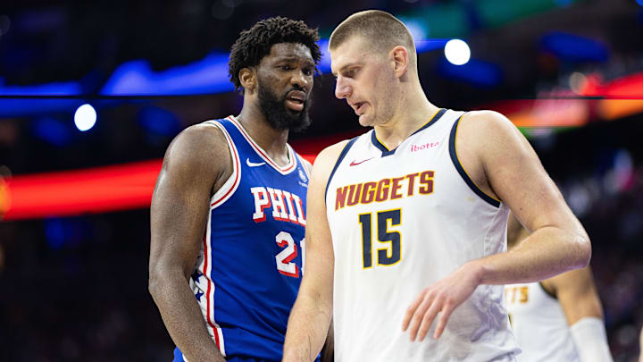 Jan 16, 2024; Philadelphia, Pennsylvania, USA; Philadelphia 76ers center Joel Embiid (21) glances at Denver Nuggets center Nikola Jokic (15) during a break in action in the third quarter at Wells Fargo Center. Mandatory Credit: Bill Streicher-Imagn Images
