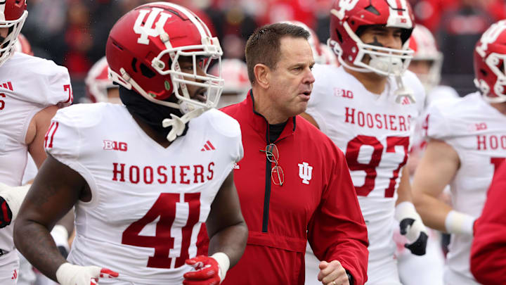 Indiana coach Curt Cignetti, defensive end Lanell Carr Jr. (41) and defensive lineman Mario Landino (97) run onto the field before playing Ohio State. 