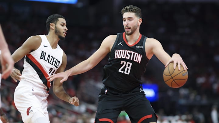 Nov 14, 2025; Houston, Texas, USA;  Houston Rockets center Alperen Sengun (28) dribbles the ball as Portland Trail Blazers forward Kris Murray (24) defends during the second quarter at Toyota Center. Mandatory Credit: Troy Taormina-Imagn Images