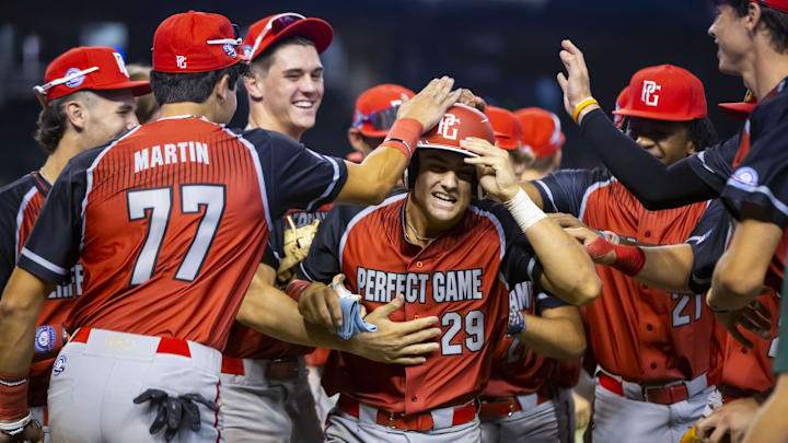West catcher Ryder Helfrick (29) celebrates with teammates after scoring.
