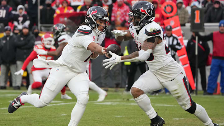Jan 18, 2025; Kansas City, Missouri, USA; Houston Texans quarterback C.J. Stroud (7) hands off the ball to running back Joe Mixon (28) against the Kansas City Chiefs during the second quarter of a 2025 AFC divisional round game at GEHA Field at Arrowhead Stadium. Mandatory Credit: Denny Medley-Imagn Images