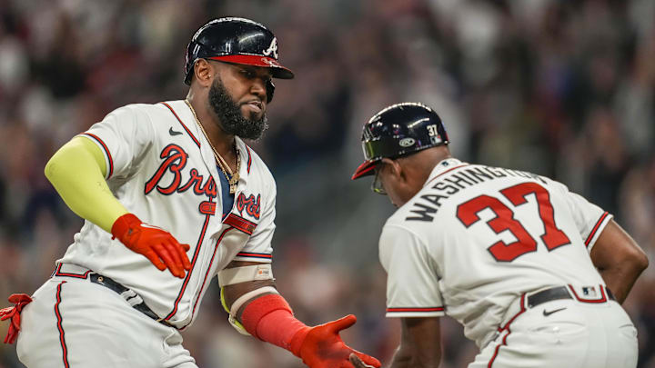 Atlanta Braves designated hitter Marcell Ozuna (20) reacts with third base coach Ron Washington