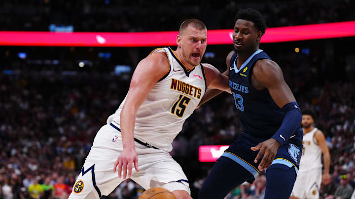 Apr 11, 2025; Denver, Colorado, USA; Memphis Grizzlies forward Jaren Jackson Jr. (13) defends on Denver Nuggets center Nikola Jokic (15) in the fourth quarter at Ball Arena. Mandatory Credit: Ron Chenoy-Imagn Images