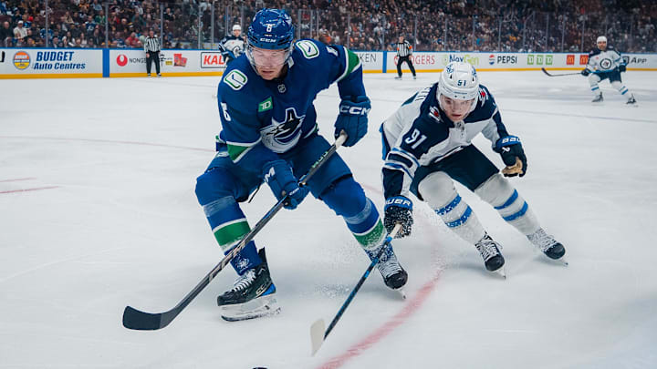 Mar 18, 2025; Vancouver, British Columbia, CAN; Winnipeg Jets forward Cole Perfetti (91) stick checks Vancouver Canucks forward Brock Boeser (6) in the third period at Rogers Arena. Mandatory Credit: Bob Frid-Imagn Images