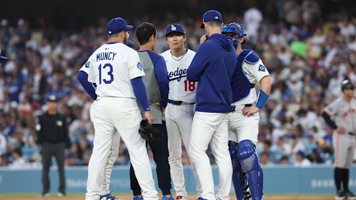 Jun 13, 2025; Los Angeles, California, USA; Los Angeles Dodgers starting pitcher Yoshinobu Yamamoto (18) is listed on the mound during the third inning against the San Francisco Giants at Dodger Stadium. Mandatory Credit: William Navarro-Imagn Images