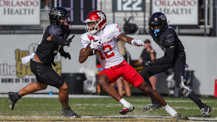 Nov 25, 2023; Orlando, Florida, USA; Houston Cougars wide receiver Stephon Johnson (12) runs the ball as UCF Knights linebacker Kam Moore (30) and defensive back Quadric Bullard (10) during the second half at FBC Mortgage Stadium. Mandatory Credit: Mike Watters-Imagn Images Nov 25, 2023; Orlando, Florida, USA; Houston Cougars wide receiver Stephon Johnson (12) runs the ball as UCF Knights linebacker Kam Moore (30) and defensive back Quadric Bullard (10) during the second half at FBC Mortgage Stadium. Mandatory Credit: Mike Watters-Imagn Images