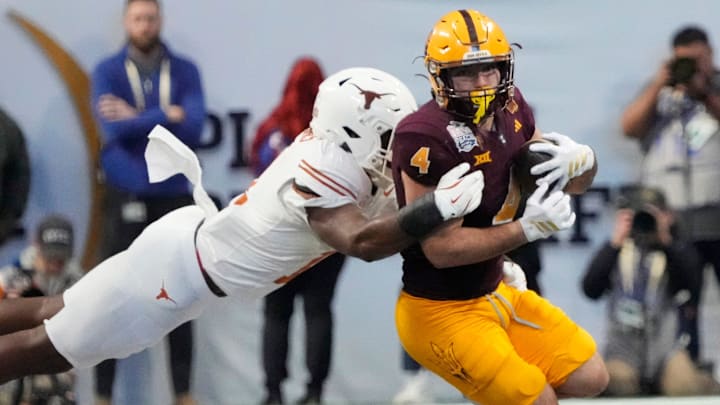Arizona State running back Cam Skattebo (4) is tackled by Texas linebacker Colin Simmons (11) during the fourth quarter in the Chick-fil-A Peach Bowl in Atlanta on Wednesday, Jan. 1, 2025.