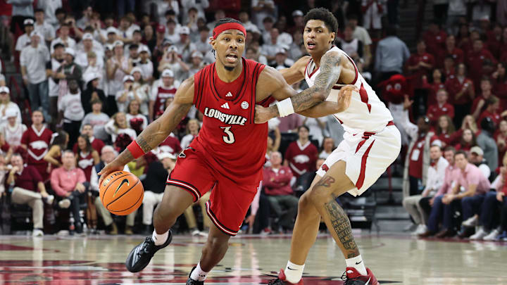 Dec 3, 2025; Fayetteville, Arkansas, USA; Louisville Cardinals guard Ryan Conwell (3) dribbles around Arkansas Razorbacks guard Meleek Thomas (1) during the second half at Bud Walton Arena. Arkansas won 89-80. Mandatory Credit: Nelson Chenault-Imagn Images