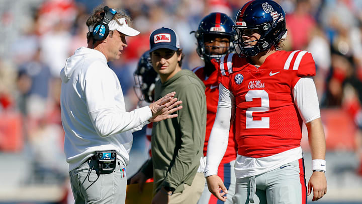 Nov 18, 2023; Oxford, Mississippi, USA; Mississippi Rebels head coach Lane Kiffin (left) talks with Mississippi Rebels quarterback Jaxson Dart (2) during a time out during the first half against the Louisiana Monroe Warhawks at Vaught-Hemingway Stadium. Mandatory Credit: Petre Thomas-Imagn Images