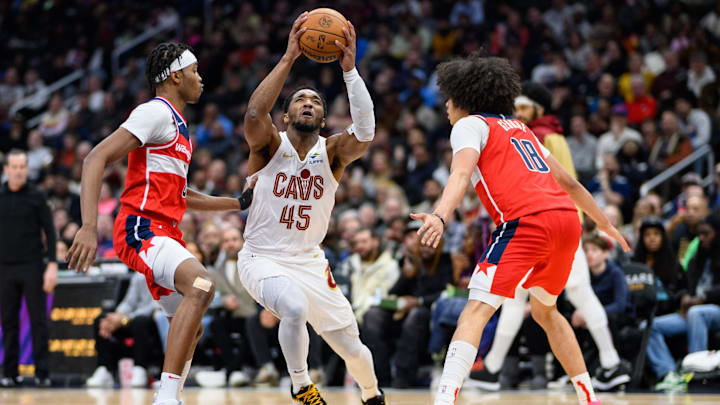 Feb 7, 2025; Washington, District of Columbia, USA; Cleveland Cavaliers guard Donovan Mitchell (45) drives to the basket against Washington Wizards forward Kyshawn George (18) and guard Bilal Coulibaly (0) during the third quarter at Capital One Arena. Mandatory Credit: Reggie Hildred-Imagn Images