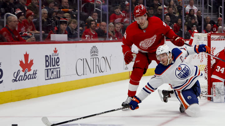 Edmonton Oilers center Connor McDavid (97) and Detroit Red Wings defenseman Moritz Seider (53) battle for the puck.