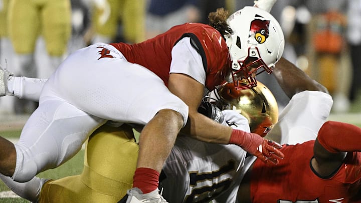 Oct 7, 2023; Louisville, Kentucky, USA; Louisville Cardinals defensive lineman Ashton Gillotte (9) sacks Notre Dame Fighting Irish quarterback Sam Hartman (10) during the second half at L&N Federal Credit Union Stadium. Louisville defeated Notre Dame 33-20. Mandatory Credit: Jamie Rhodes-Imagn Images
