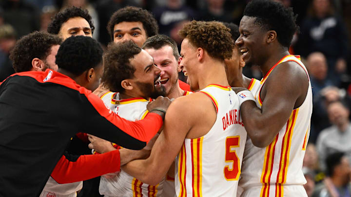 Trae Young #11 of the Atlanta Hawks is mobbed by teammates after his game-winning shot against the Utah Jazz.