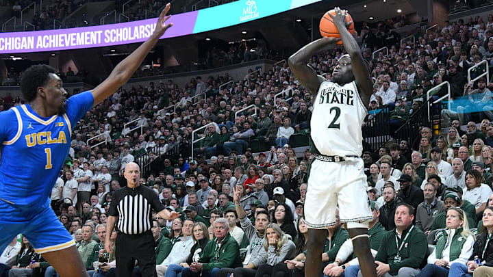 Feb 17, 2026; East Lansing, Michigan, USA; Michigan State Spartans guard Kur Teng (2) makes a three point shot over UCLA Bruins center Xavier Booker (1) during the second half at Jack Breslin Student Events Center. Mandatory Credit: Dale Young-Imagn Images Feb 17, 2026; East Lansing, Michigan, USA; Michigan State Spartans guard Kur Teng (2) makes a three point shot over UCLA Bruins center Xavier Booker (1) during the second half at Jack Breslin Student Events Center. Mandatory Credit: Dale Young-Imagn Images