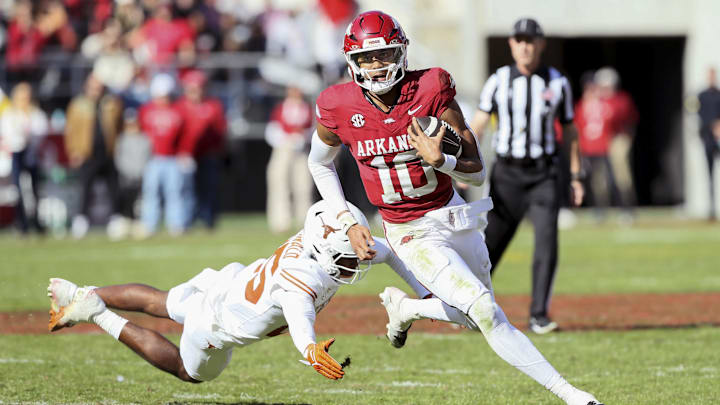 Nov 16, 2024; Fayetteville, Arkansas, USA; Arkansas Razorbacks quarterback Taylen Green (10) rushes in the third quarter as Texas Longhorns defensive back Jelani McDonald (25) defends at Donald W. Reynolds Razorback Stadium. Texas won 20-10. Mandatory Credit: Nelson Chenault-Imagn Images