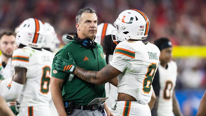 Jan 8, 2026; Glendale, AZ, USA; Miami Hurricanes head coach Mario Cristobal with defensive back Jakobe Thomas (8) against the Mississippi Rebels during the 2026 Fiesta Bowl and semifinal game of the College Football Playoff at State Farm Stadium. Mandatory Credit: Mark J. Rebilas-Imagn Images